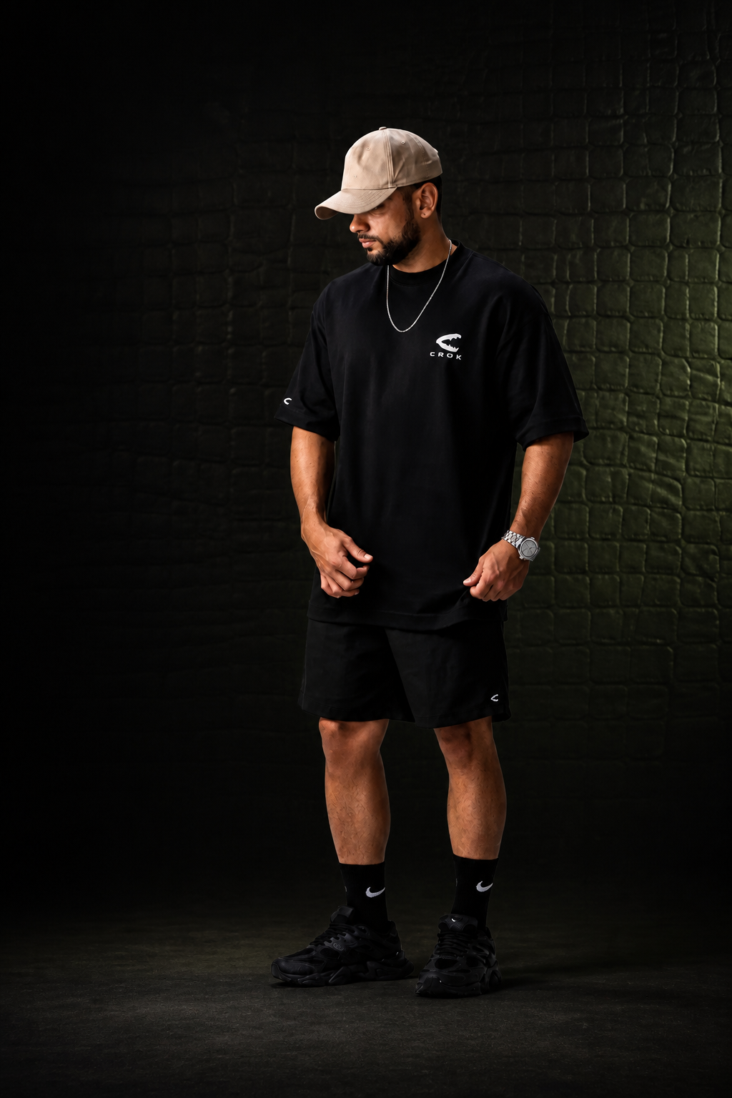 Guilherme usando oversized preta CROK em cenário escuro